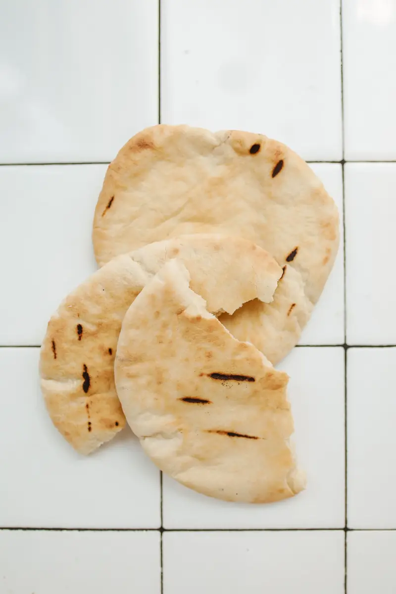 Fresh pita bread with char marks on white tiles